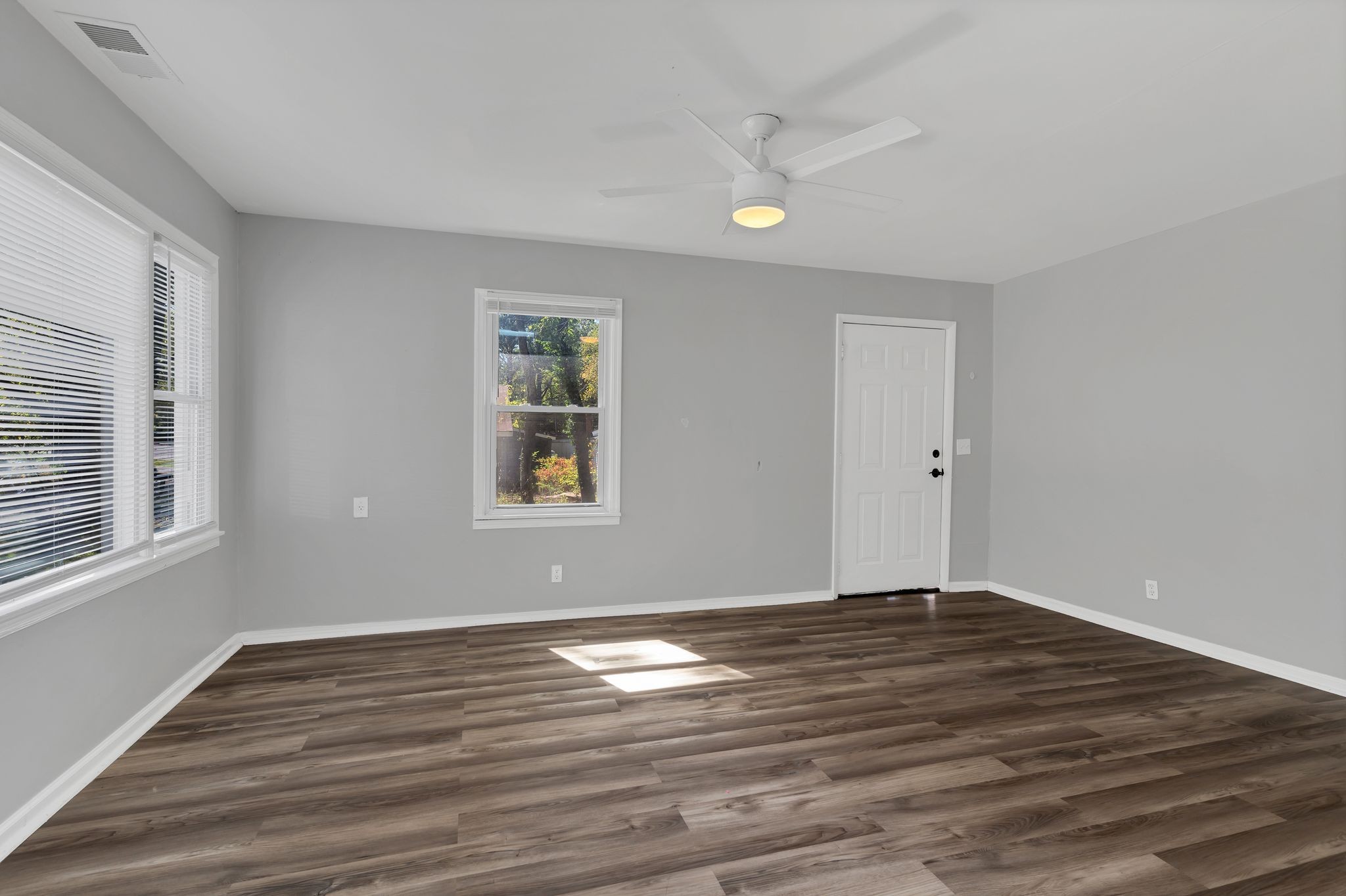 a view of wooden floor and windows in a room
