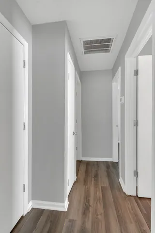 a view of a hallway with wooden floor
