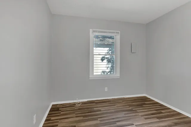a view of a room with wooden floor and window