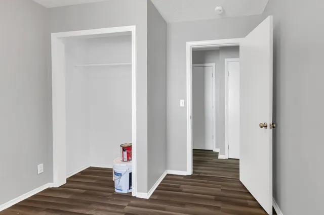 a view of a hallway with wooden floor and closet