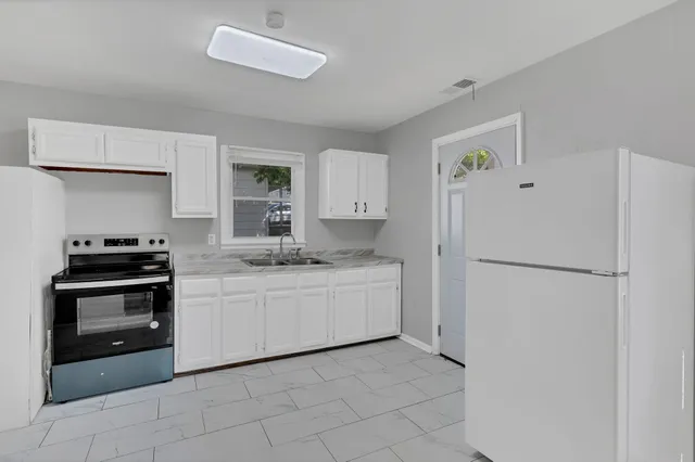 a kitchen with white cabinets and white appliances