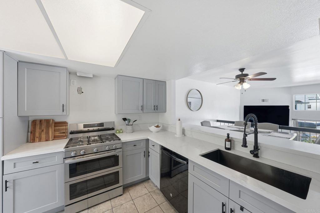 8765 Spring Canyon Drive Spring Valley, CA 91977 - Photo 11 of 37 a kitchen with a sink dishwasher a stove and a potted plant