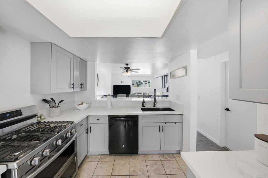 8765 Spring Canyon Drive Spring Valley, CA 91977 - Photo 13 of 37 a kitchen with a sink stove and cabinets