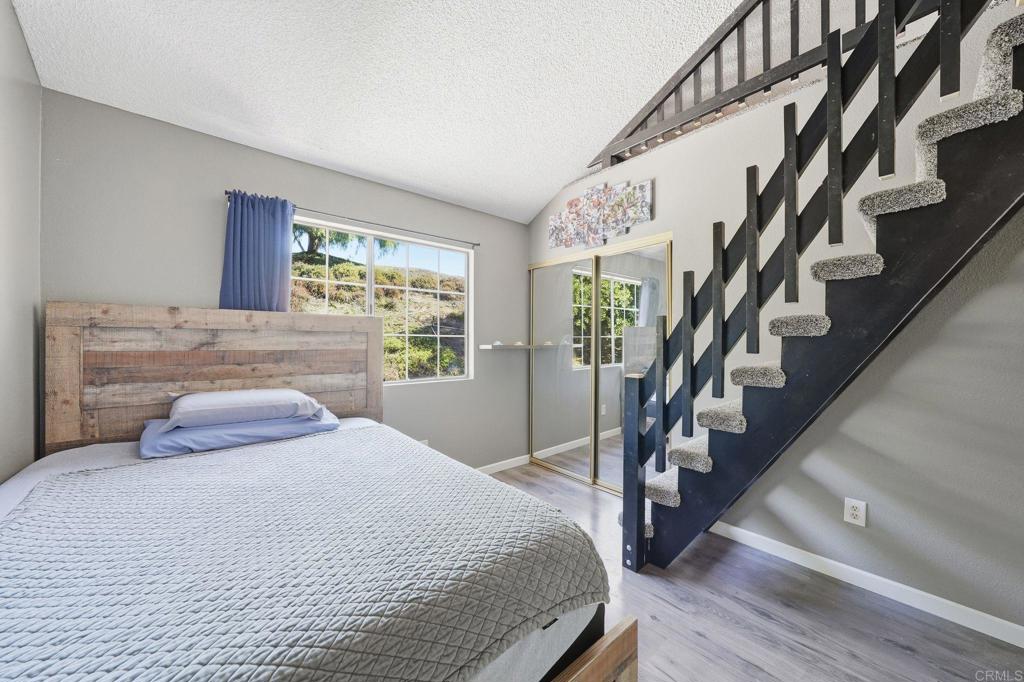 8765 Spring Canyon Drive Spring Valley, CA 91977 - Photo 29 of 37 a bedroom with a large bed and large windows with wooden floor