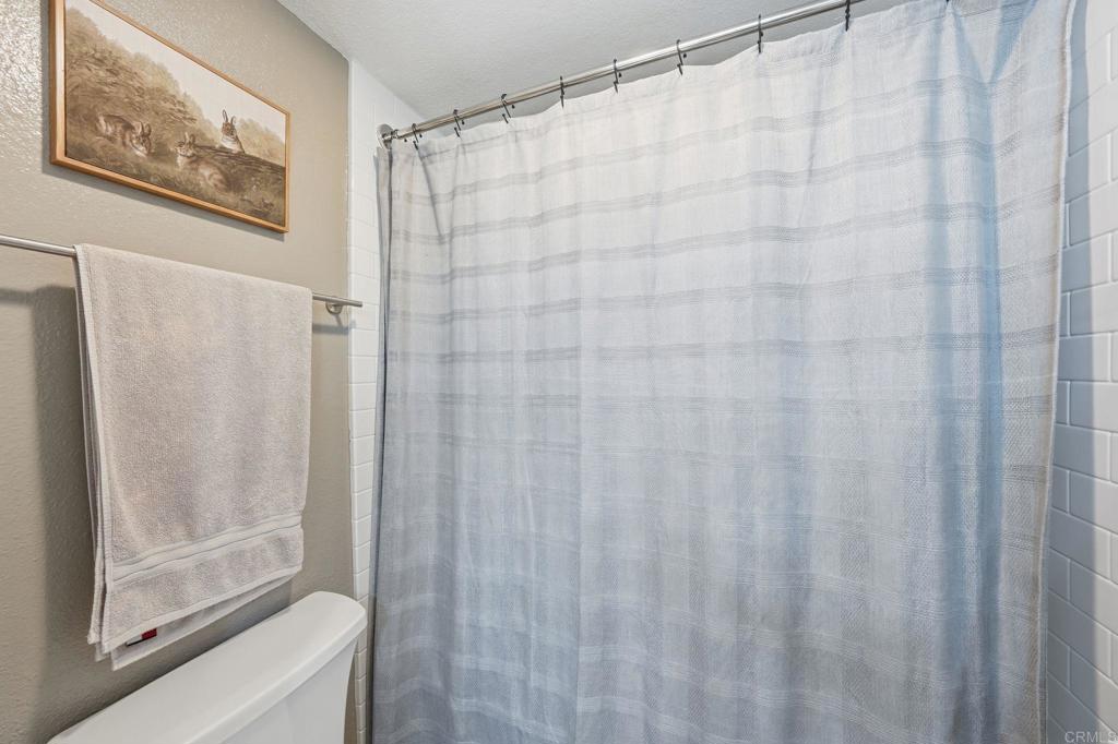 8765 Spring Canyon Drive Spring Valley, CA 91977 - Photo 34 of 37 a bathroom with a shower and a toilet next to a window