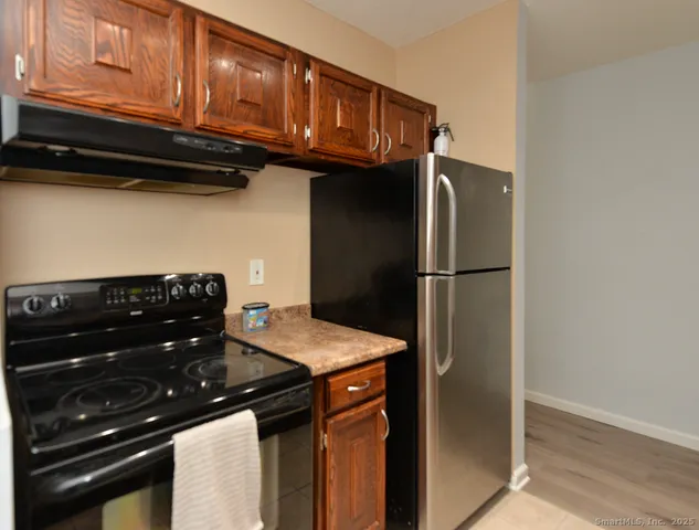 a kitchen with stainless steel appliances granite countertop a refrigerator and a stove