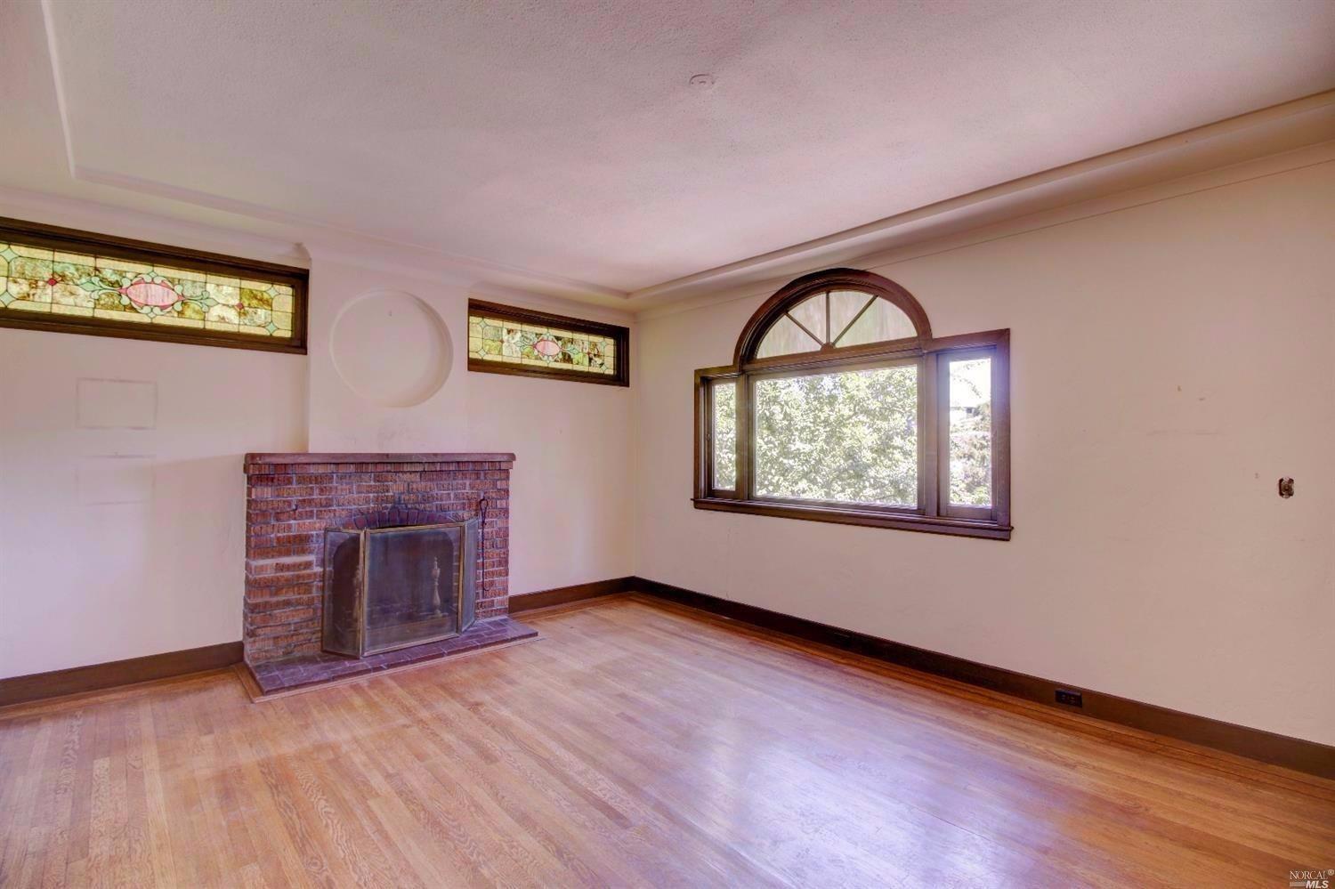 21 Fremont Road San Rafael, CA 94901 - Photo 1 of 1 an empty room with windows fireplace and wooden floor