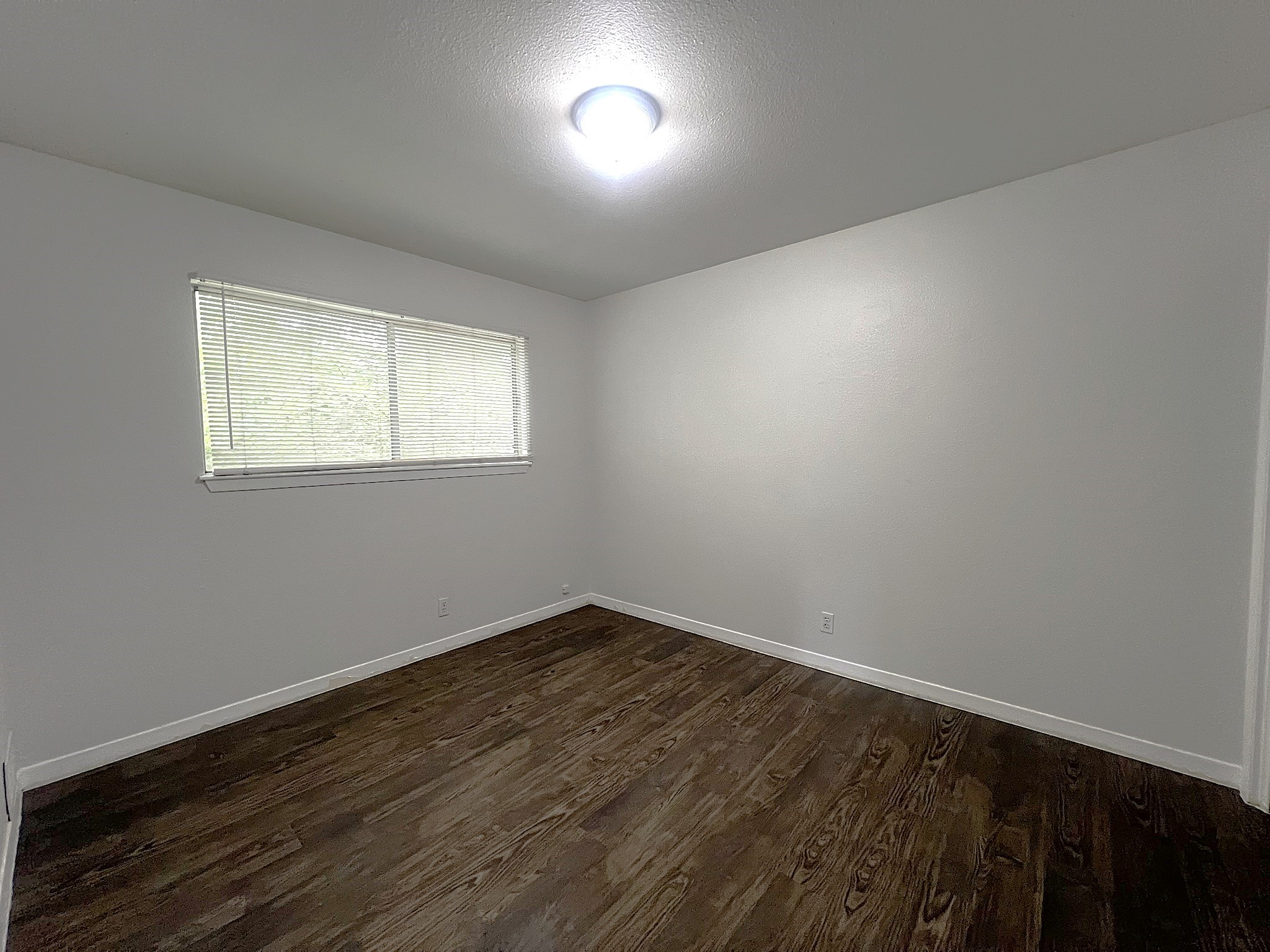 1037 East 44th Street, Unit 101 Austin, TX 78751 - Photo 6 of 9 an empty room with wooden floor and windows