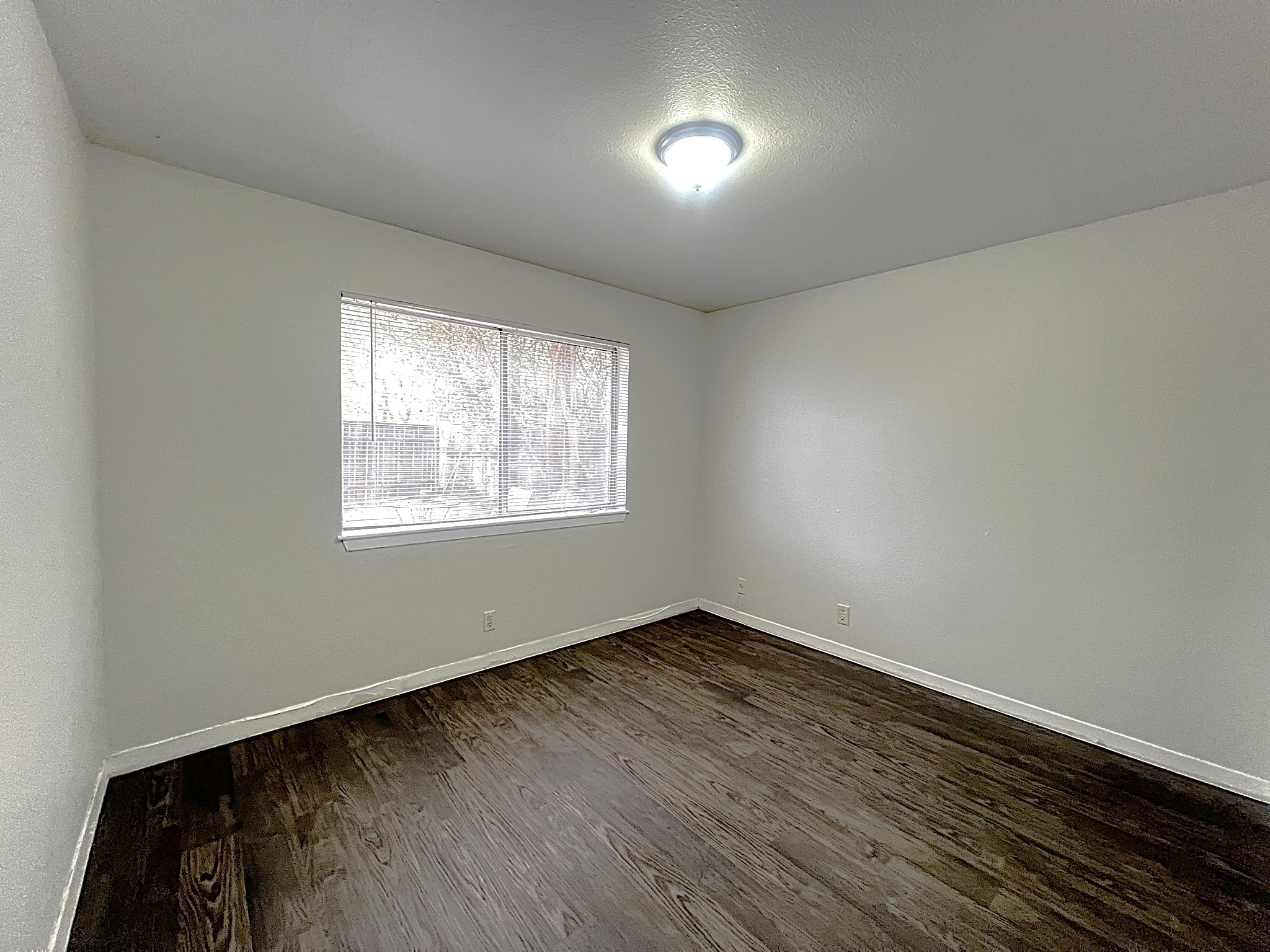 1037 East 44th Street, Unit 101 Austin, TX 78751 - Photo 7 of 9 an empty room with wooden floor and windows