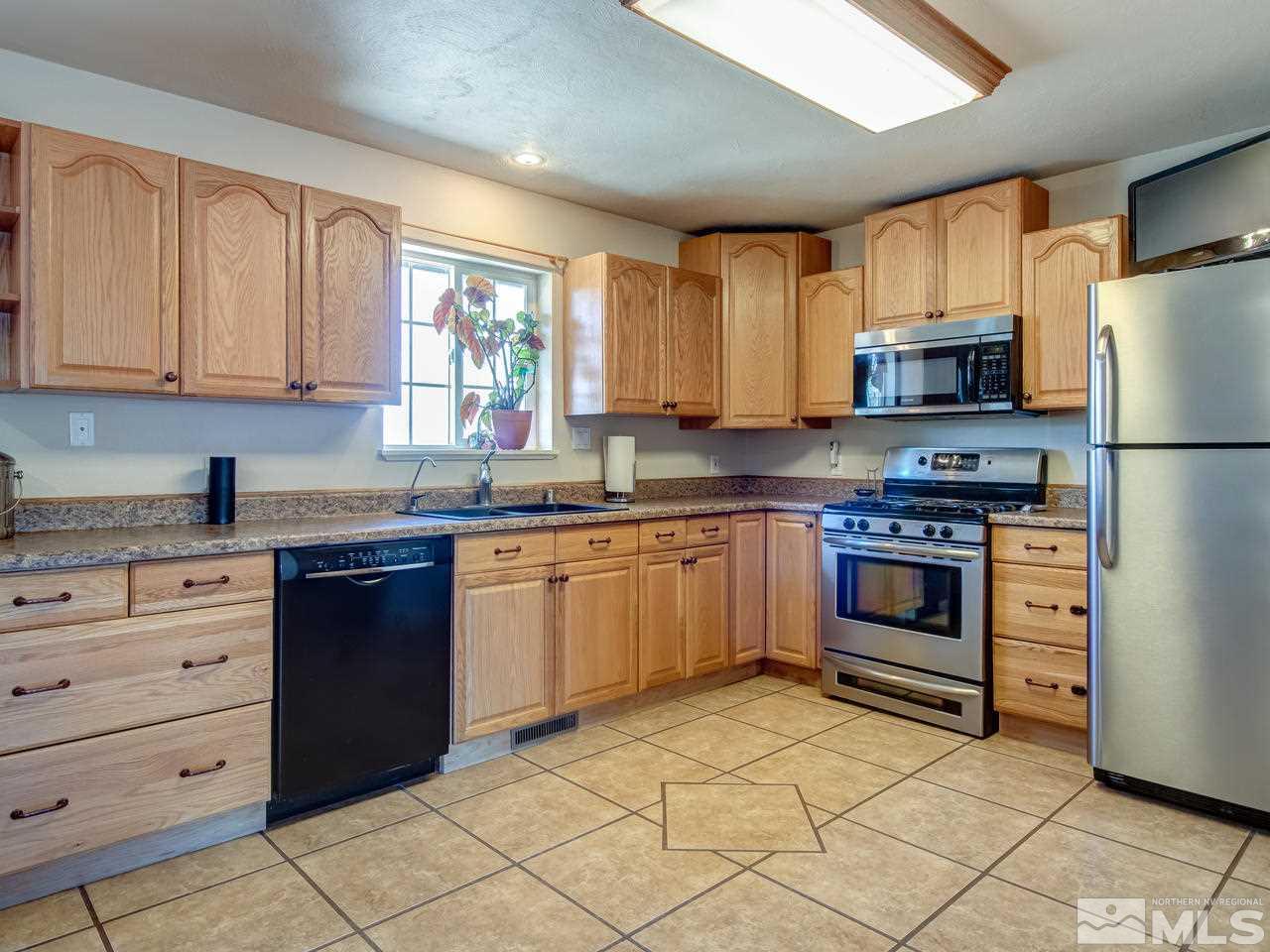 805 Hidden Canyon Road Reno, NV 89510 - Photo 6 of 24 a kitchen with granite countertop a refrigerator stove top oven and sink