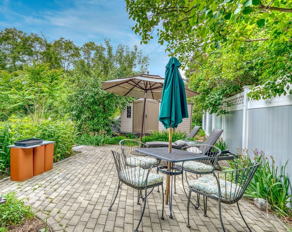 14 Paul Road Medford, MA 02155 - Photo 28 of 42 a patio with a table and chairs and potted plants