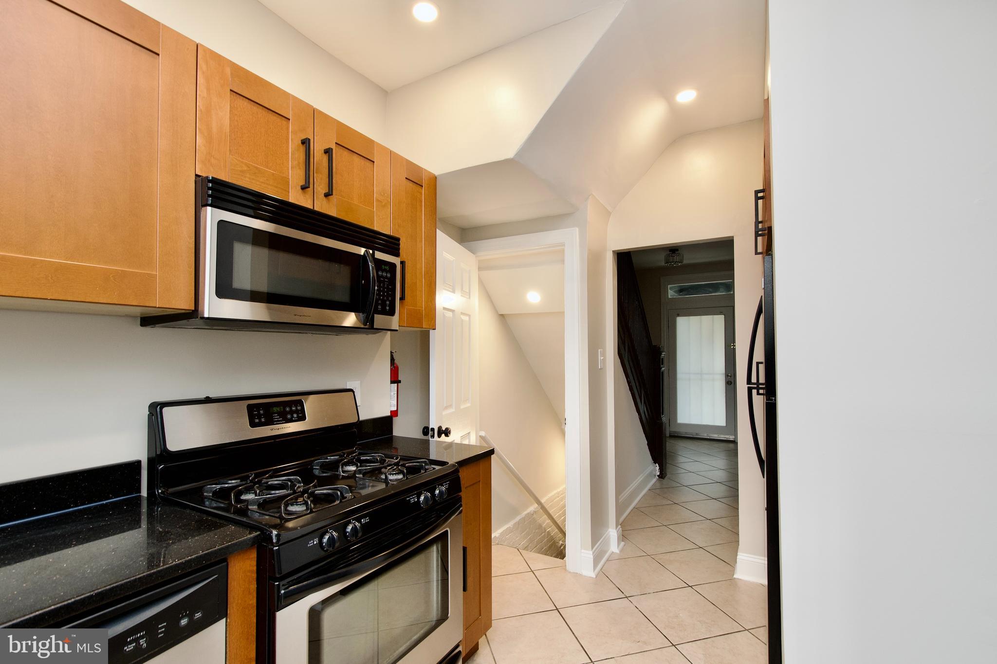 116 Todd Place Northeast Washington, DC 20002 - Photo 13 of 34 a kitchen with stainless steel appliances granite countertop a stove and a microwave