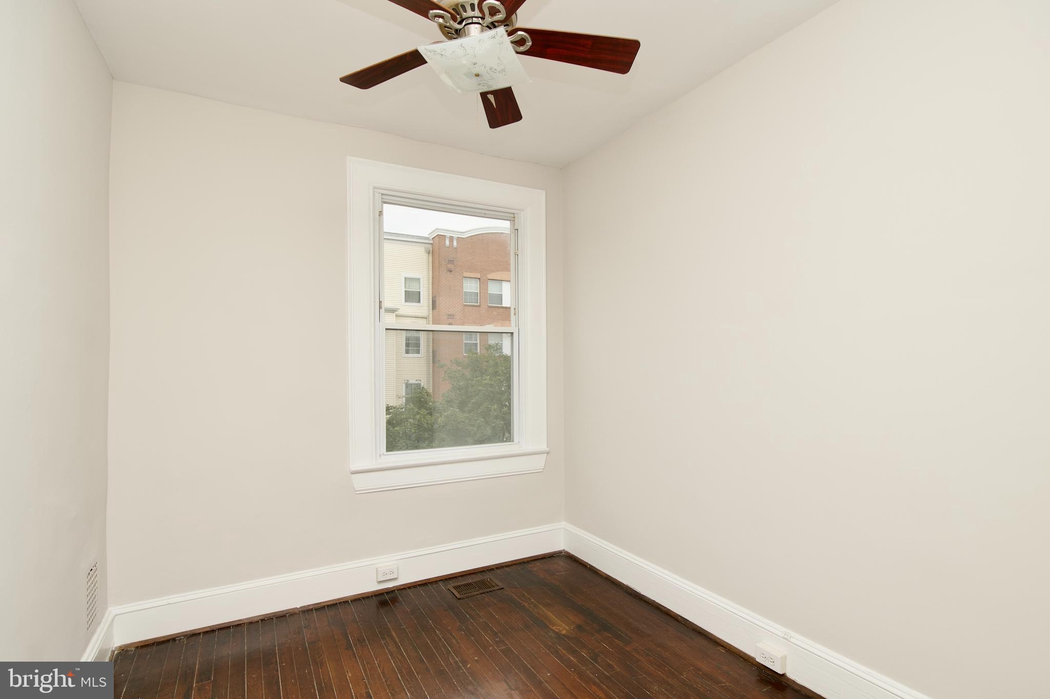 116 Todd Place Northeast Washington, DC 20002 - Photo 18 of 34 an empty room with wooden floor chandelier fan and windows