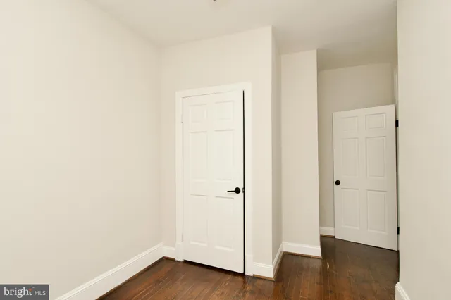 an empty room with wooden floor and ceiling fan