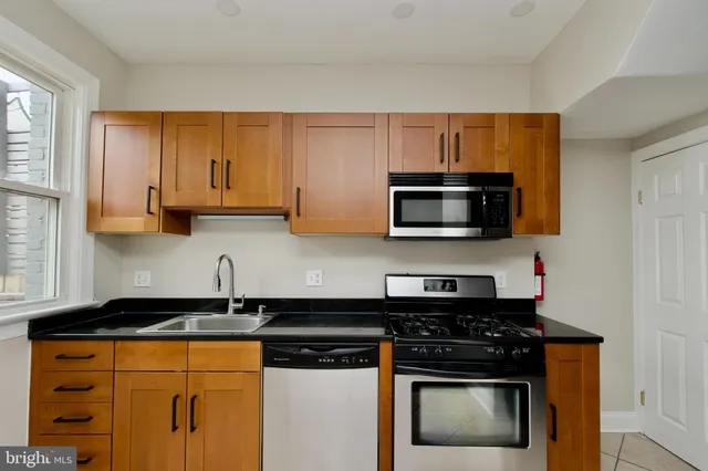 a kitchen with stainless steel appliances granite countertop a stove and a microwave