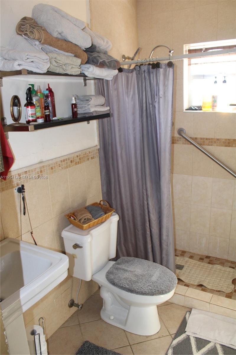 6030 Southwest 93rd Court Miami, FL 33173 - Photo 7 of 9 a white toilet sitting next to a bathroom sink