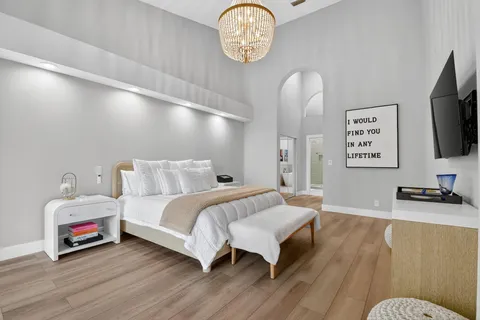 a bedroom with bed and a flat tv screen on the dresser