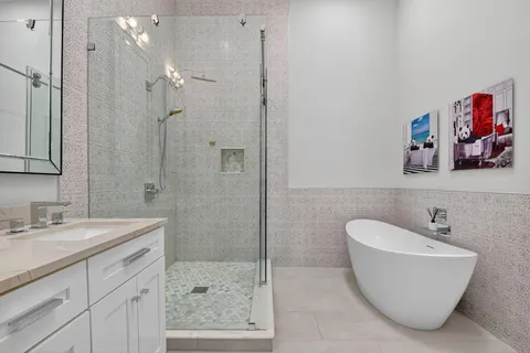 a bathroom with a double vanity sink mirror and bathtub