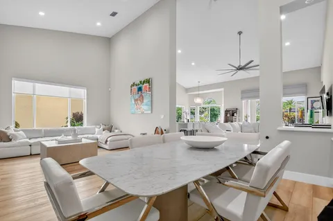 a living room with furniture kitchen view and a large window