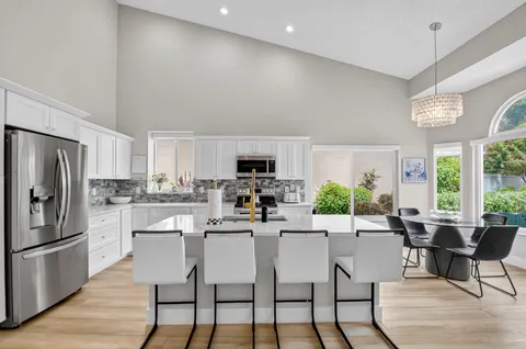 a kitchen with a dining table chairs and refrigerator