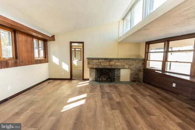 a view of an empty room with a fireplace and a window