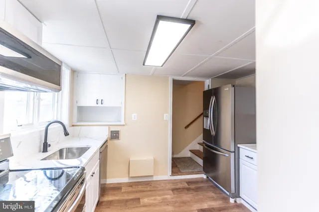 a kitchen with stainless steel appliances granite countertop a sink and a refrigerator
