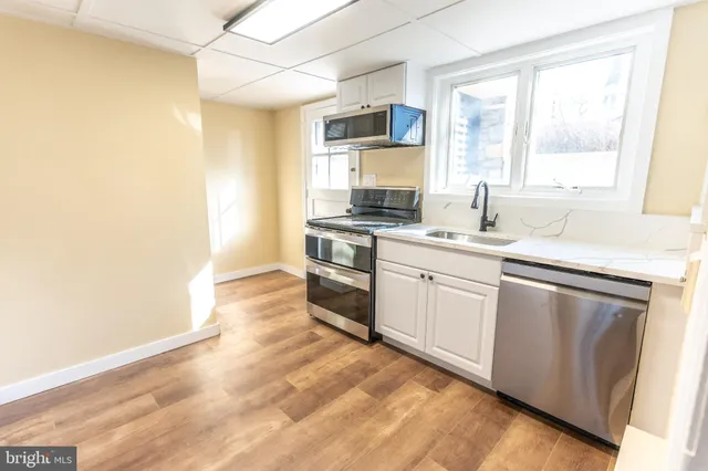 a kitchen with granite countertop white cabinets and white appliances