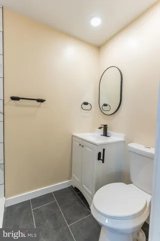 a bathroom with a toilet a sink and mirror