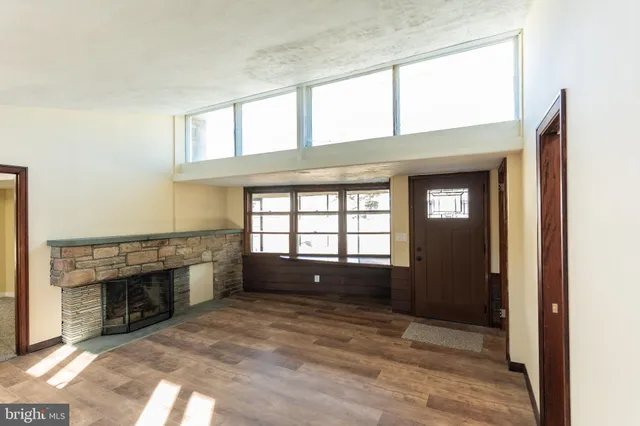 a view of empty room with a fireplace and windows