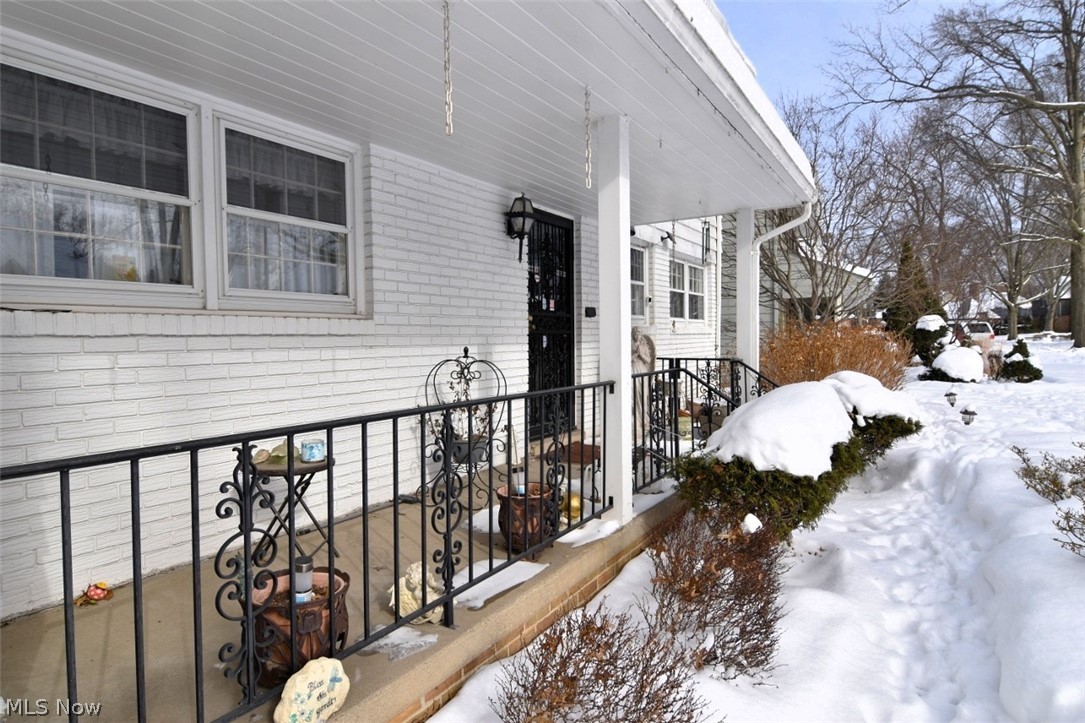 15991 Henley Road Cleveland, OH 44112 - Photo 2 of 36 Snow covered property entrance featuring wood siding and a porch