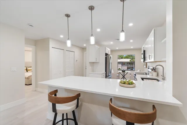 a kitchen with a dining table chairs and kitchen view