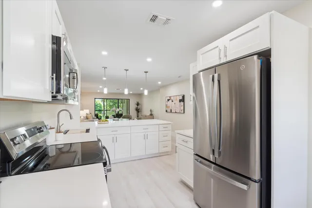 a kitchen with a refrigerator sink and cabinets