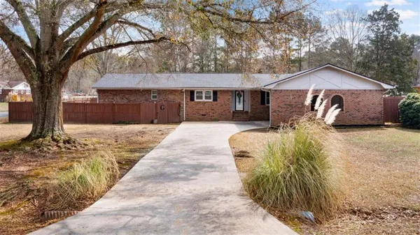 a front view of a house with a yard covered in snow