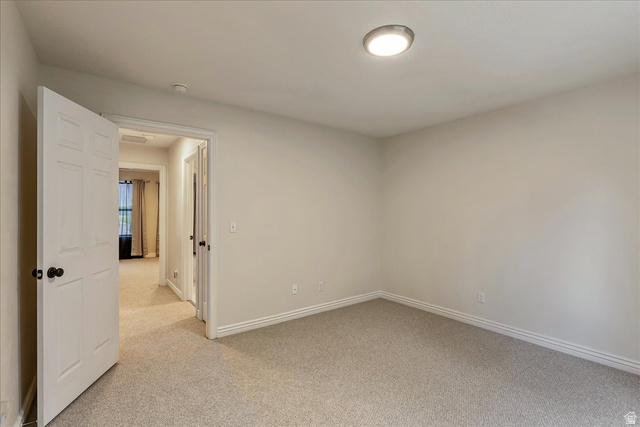 38 South 1000th Street East Payson, UT 84651 - Photo 14 of 19 Interior space featuring light grey wall paint, grey carpet flooring, white baseboards, a white paneled door with black hardware, and a flush-mount ceiling light