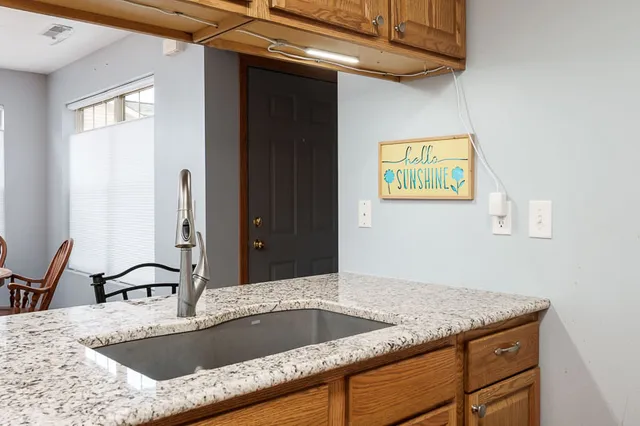 a kitchen with a granite countertop sink and natural light