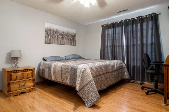 a bedroom with a bed a couch and a chandelier