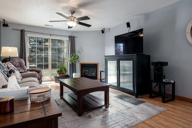 a living room with furniture a flat screen tv and a fireplace