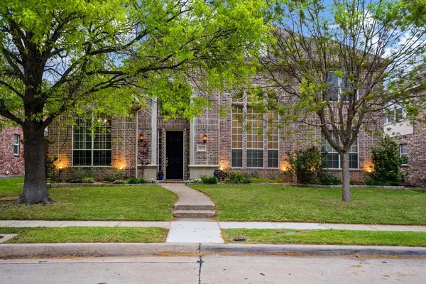 a view of a big yard in front of a brick house