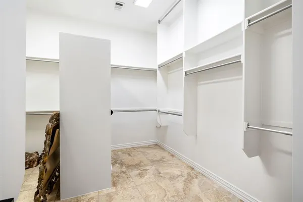 a view of walk in closet with clothes and shoes