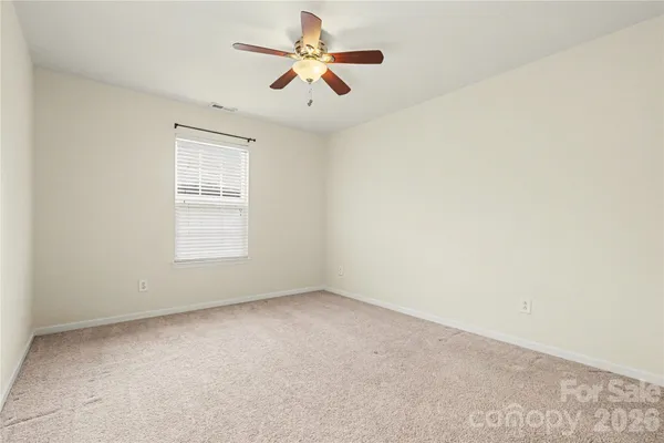 an empty room with a window and a ceiling fan