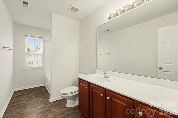 a bathroom with a sink a toilet and a mirror