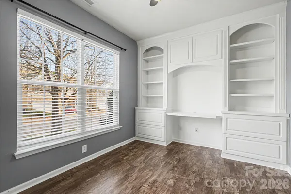 a view of an empty room with a window and cabinet