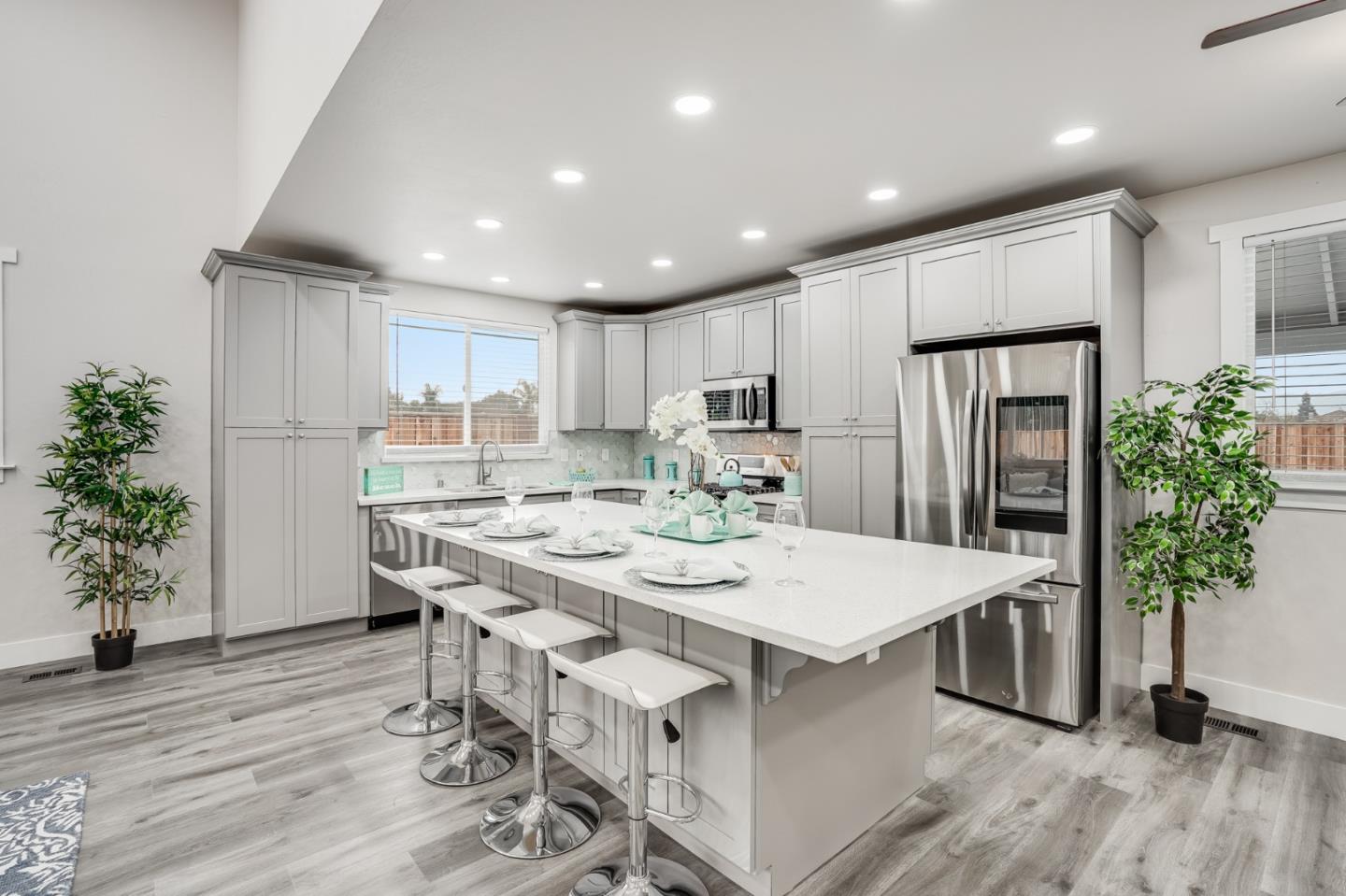 17675 Laurel Road Morgan Hill, CA 95037 - Photo 13 of 48 a kitchen with stainless steel appliances kitchen island a table chairs refrigerator and microwave