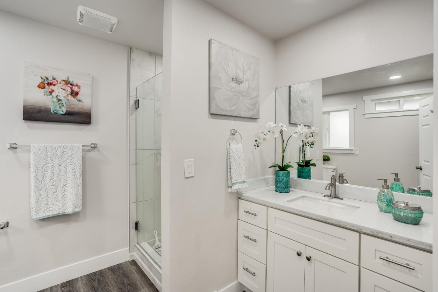 17675 Laurel Road Morgan Hill, CA 95037 - Photo 28 of 48 a bathroom with a granite countertop sink a mirror a vanity and shower