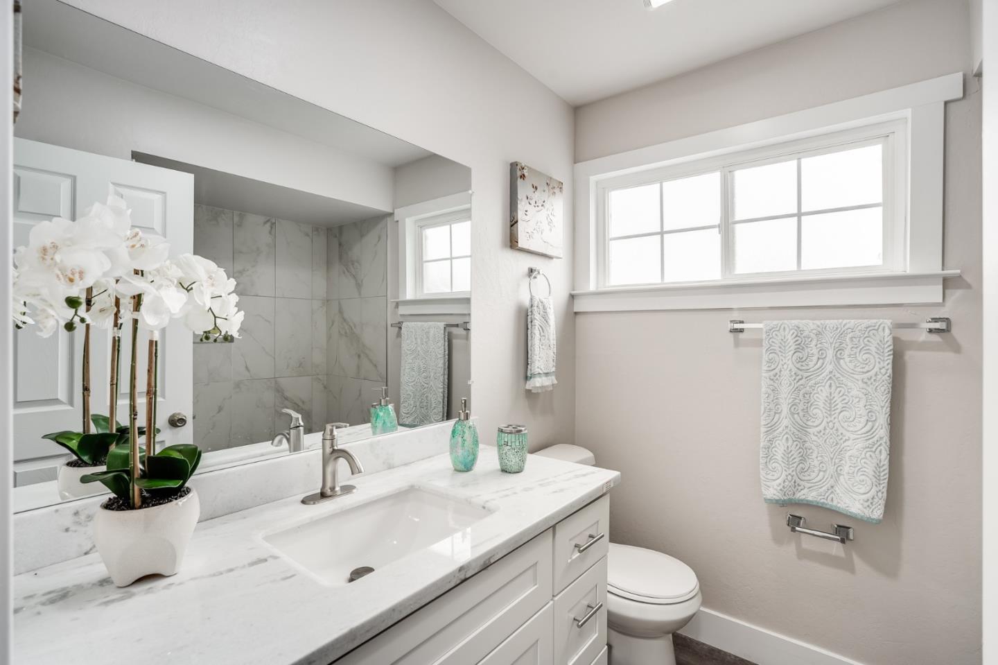 17675 Laurel Road Morgan Hill, CA 95037 - Photo 31 of 48 a bathroom with a granite countertop sink a toilet a mirror and shower