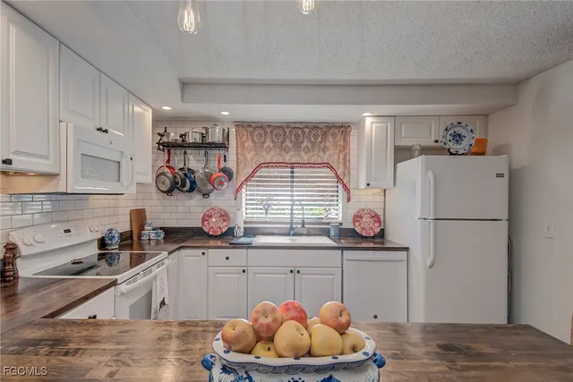 a kitchen with stainless steel appliances granite countertop a sink a stove and a refrigerator