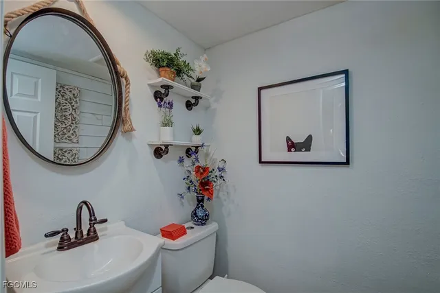 a bathroom with a toilet a sink and a mirror