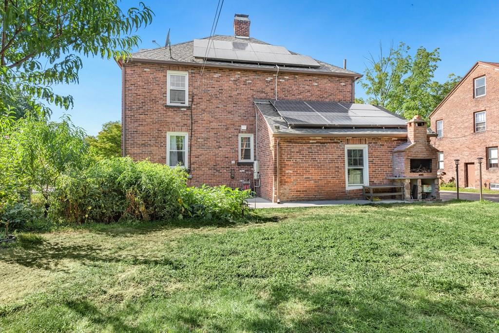 3 Silver Street Springfield, MA 01107 - Photo 3 of 20 a brick house with a small yard and large trees