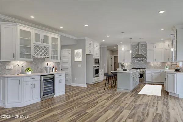 a kitchen with stainless steel appliances kitchen island granite countertop a stove a sink a refrigerator and cabinets