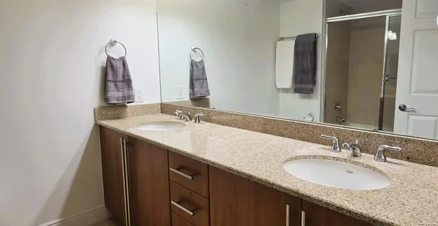 a bathroom with a granite countertop sink and a mirror